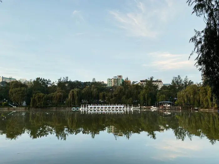 The lake at Burnham Park in Baguio reflecting trees and a blue sky